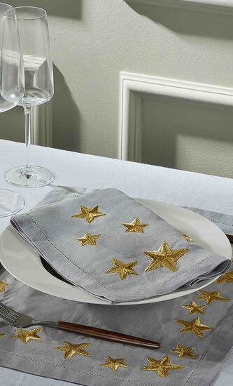 مفرش أطباق من إبداع المصمّمة أوريلي بيدرمان مزيّن بنقش على شكل نجوم ذهبية