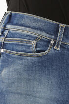 بنطال جينز باهت اللون بقصّة ضيقة من أعلى وواسعة من أسفل